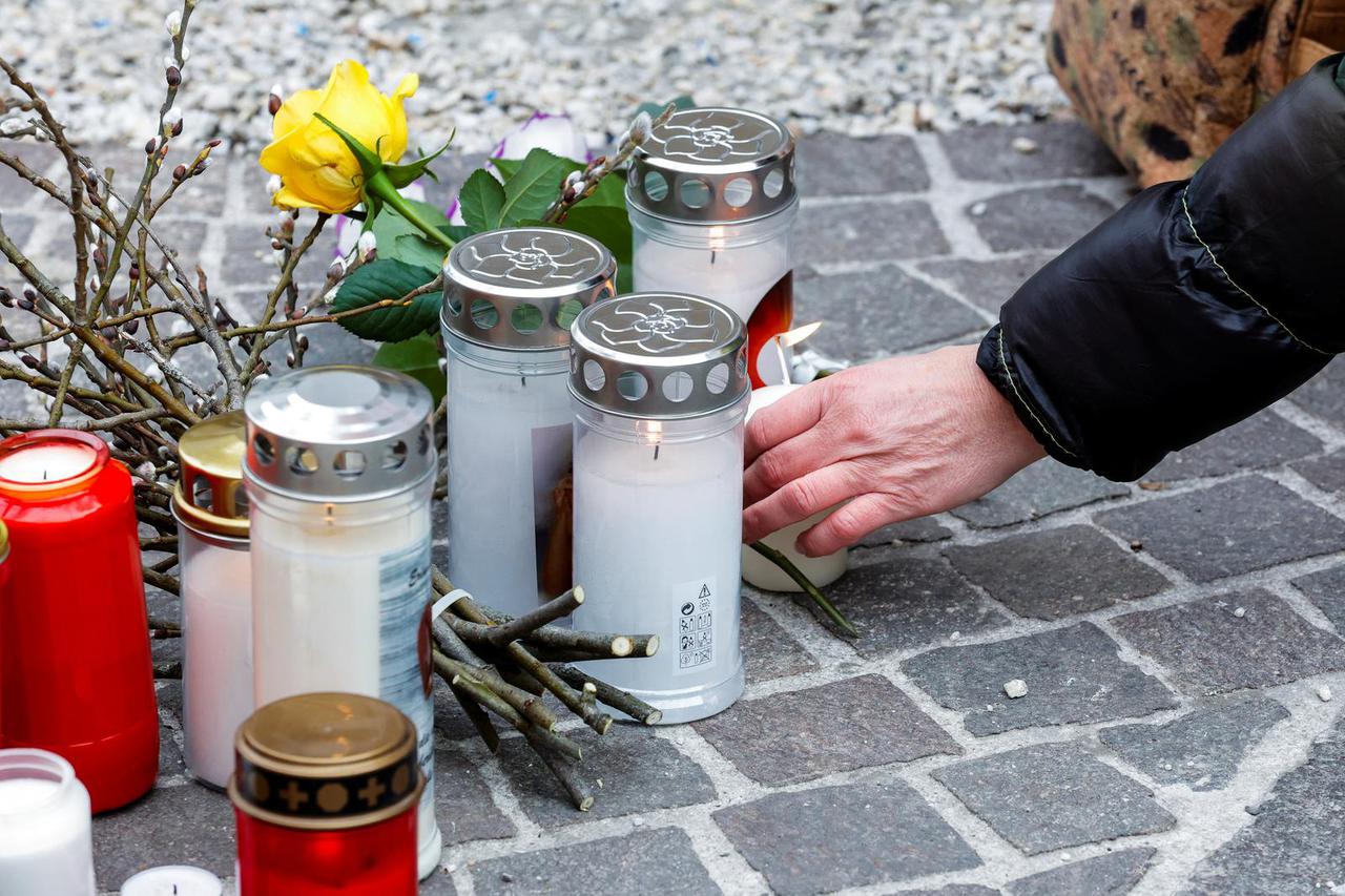 Candles and flowers sit at the scene where a 14-year-old boy was killed and several others were wounded in a stabbing attack, in the town of Villach