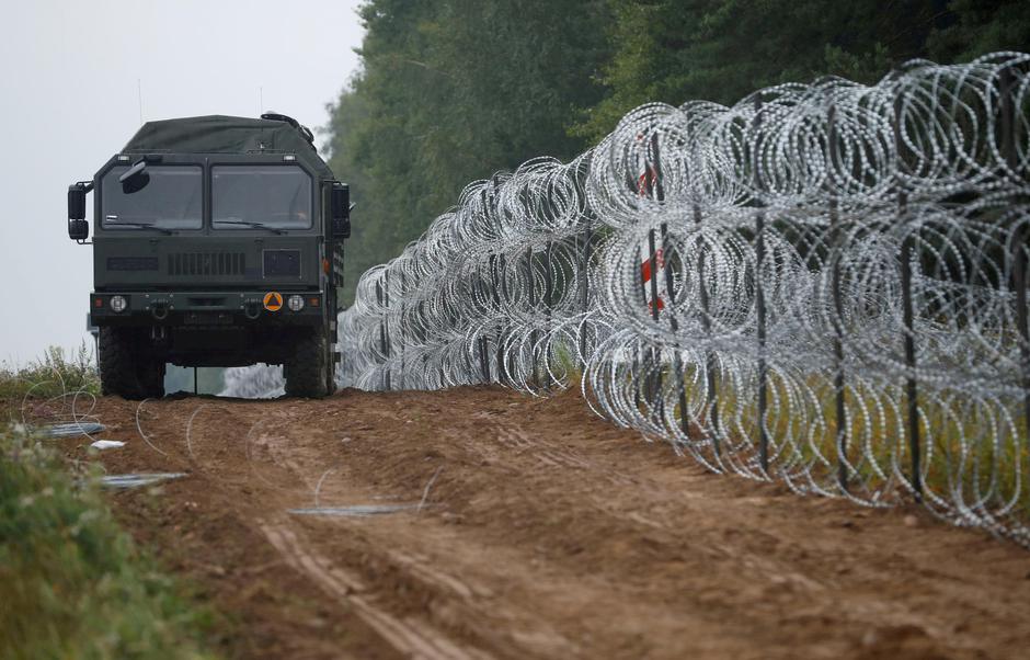 FILE PHOTO: Polish soldiers build a fence on the border between Poland and Belarus near the village of Nomiki