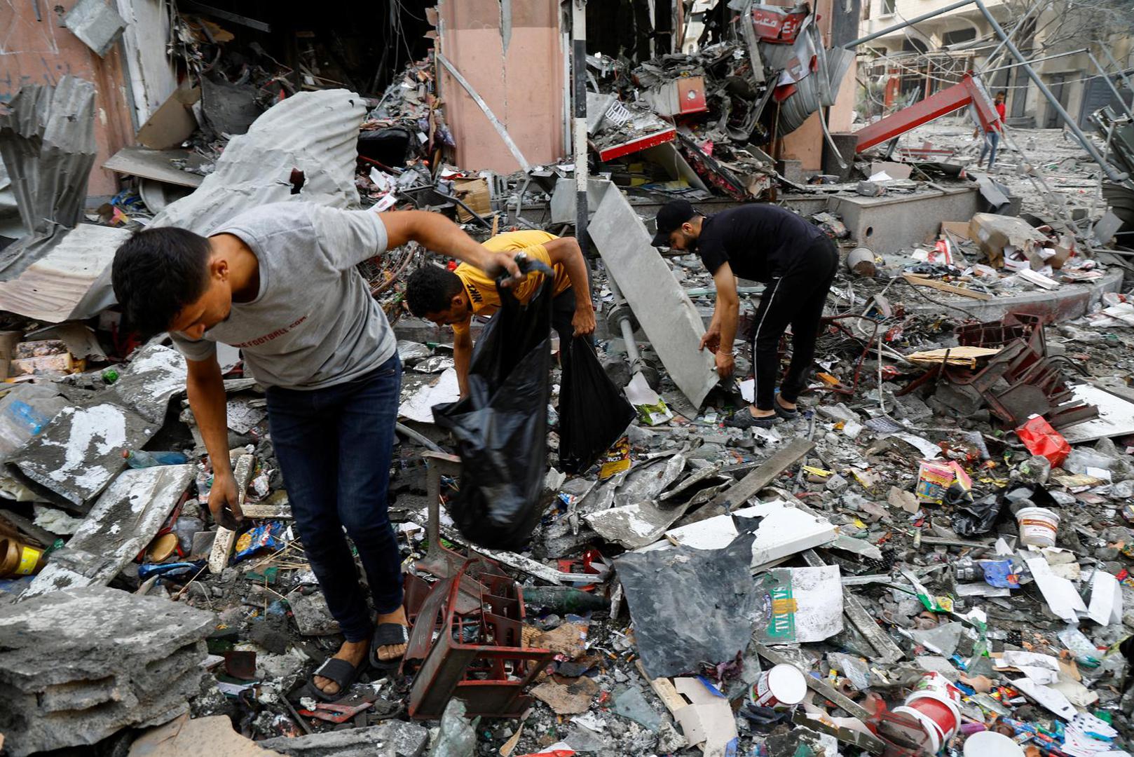 Palestinians look through debris in the aftermath of Israeli strikes, in Gaza City, October 11, 2023. REUTERS/Mohammed Salem Photo: MOHAMMED SALEM/REUTERS