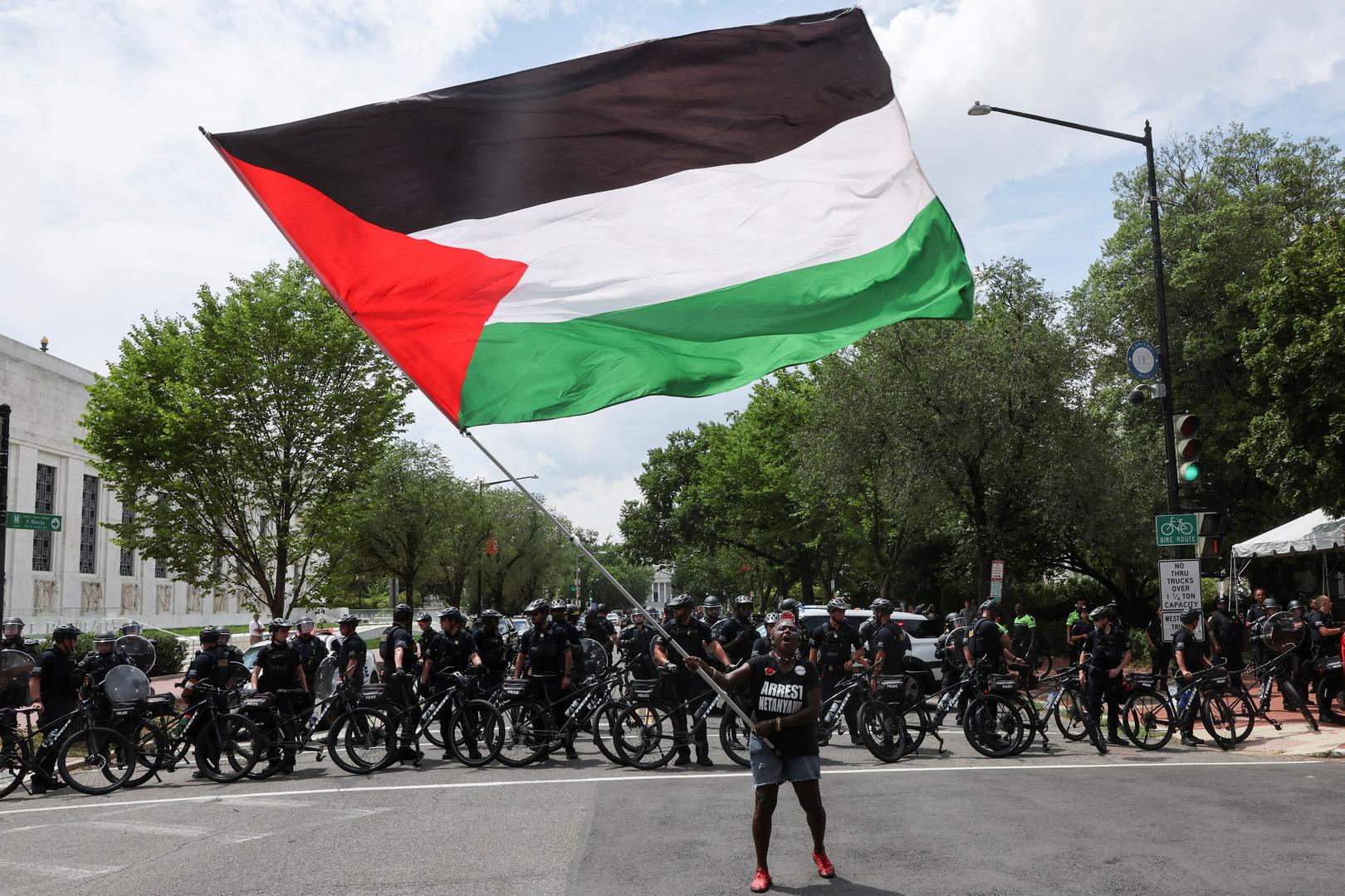 A demonstrator waves a Palestinian flag near a line of U.S. Capitol Police officers with bikes, on the day Israeli Prime Minister Benjamin Netanyahu addresses a joint meeting of Congress, on Capitol Hill, in Washington, U.S., July 24, 2024. REUTERS/Umit Bektas     TPX IMAGES OF THE DAY Photo: UMIT BEKTAS/REUTERS