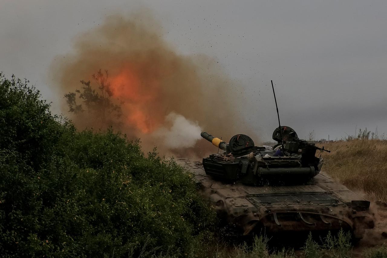 Ukrainian servicemen fire toward Russian troops with a tank at a position in Donetsk region