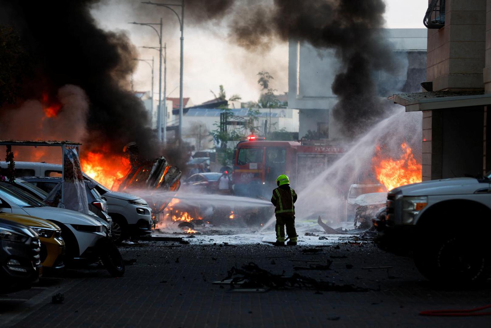 An emergency personnel works to extinguish fire after rockets launched from the Gaza Strip, as seen from the city of Ashkelon, Israel October 7, 2023. REUTERS/Amir Cohen Photo: AMIR COHEN/REUTERS