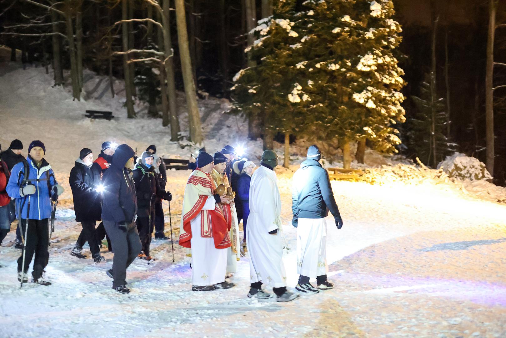 Više desetaka ljudi sudjelovalo je u noćnoj procesiji kroz šumu i gusti snijeg dok je župnik nosio malog Isusa do Jaslica u koje je spremljen na počinak. 