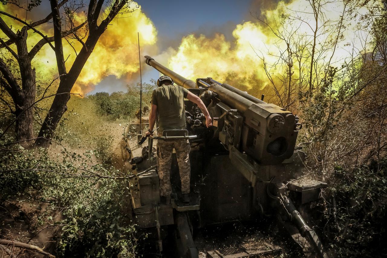 Ukrainian servicemen fire a self-propelled howitzer towards Russian troops at a frontline near the town of Chasiv Yar