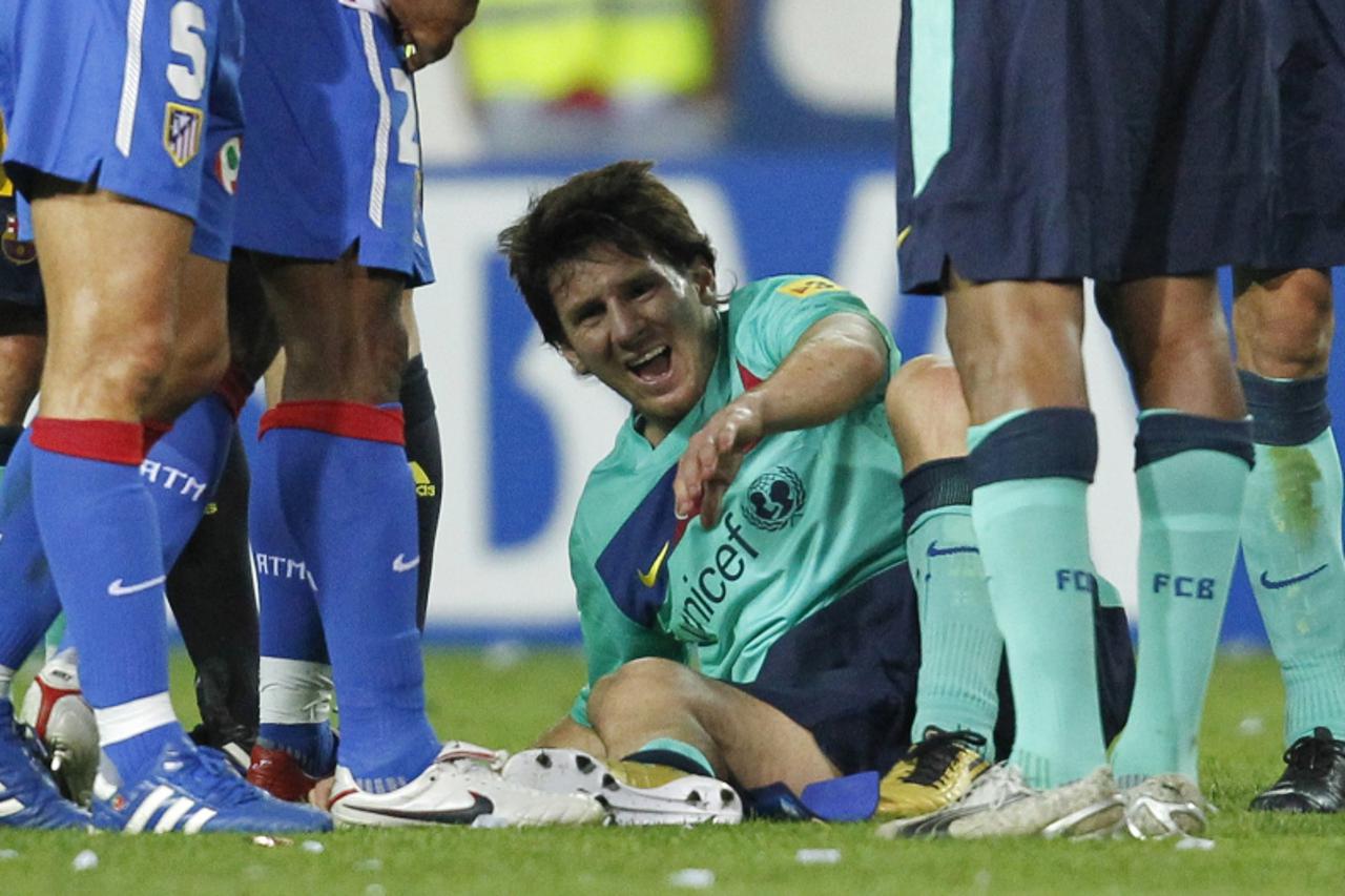 'Barcelona\'s Lionel Messi reacts after sustaining an injury in the final minutes of their Spanish first division match against Atletico Madrid at the Vicente Calderon stadium in Madrid September 19, 