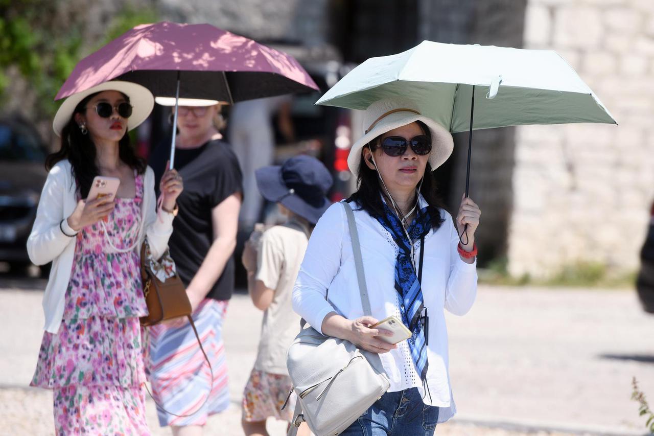 Šibenik: Spas od vru?ina turisti potražili ispod kišobrana