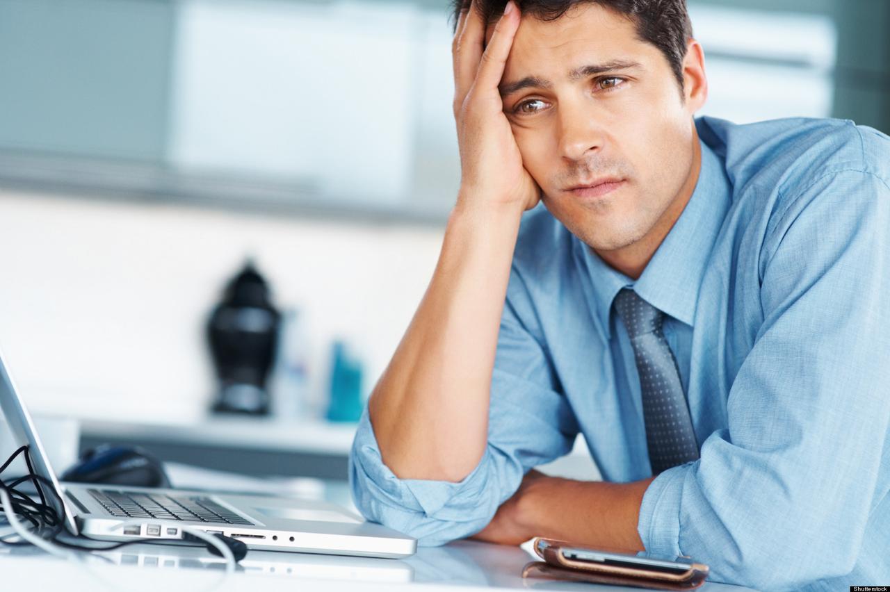 Businessman sitting at desk with hand on his face, looking worried; Shutterstock ID 70490008; PO: The Huffington Post; Job: The Huffington Post; Client: The Huffington Post; Other: The Huffington Post