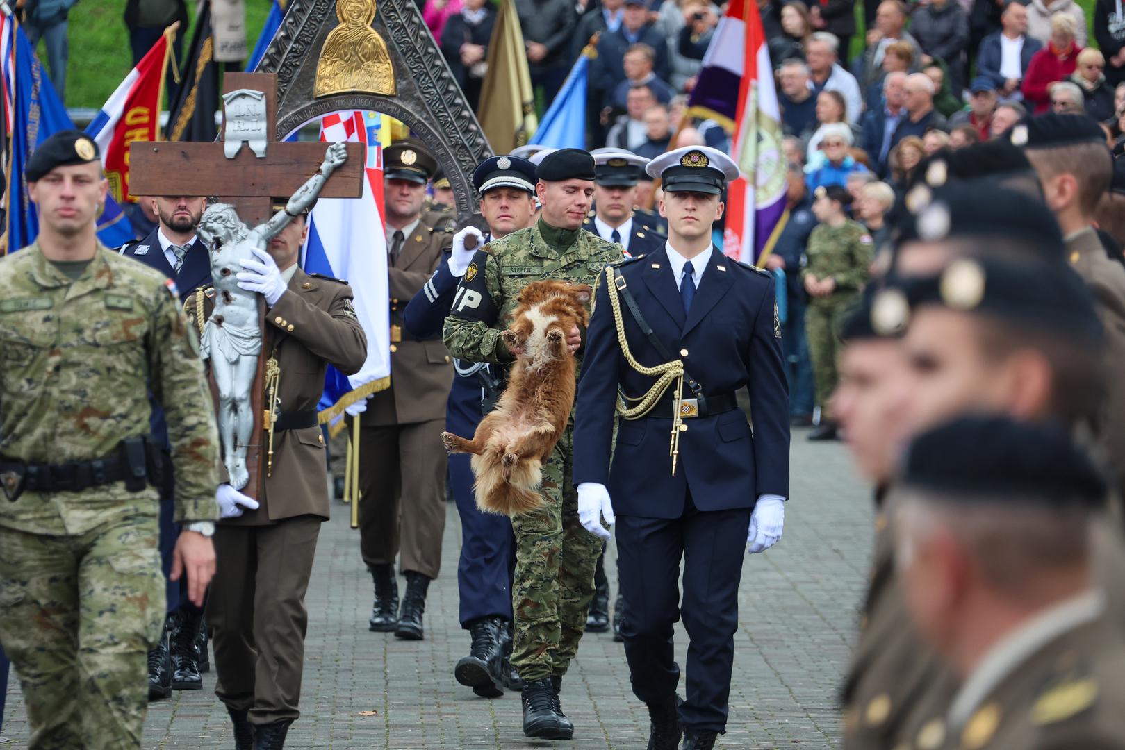 Naime, simpatični psić ipak nije uspio sa povorkom doći do oltara jer ga je u tome spriječio jedan brzi vojnik koji ga je spretno uhvatio te nosio kroz povorku pa tako stvorio idealan trenutak za nesvakidašnju fotografiju.