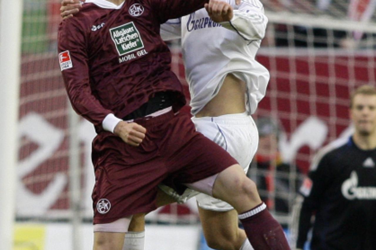 'Schalke 04\'s Christoph Metzelder (R) challenges 1. FC Kaiserslautern\'s Srdjan Lakic during their German first division Bundesliga soccer match in Kaiserslautern November 27, 2010. REUTERS/Ralph Orl