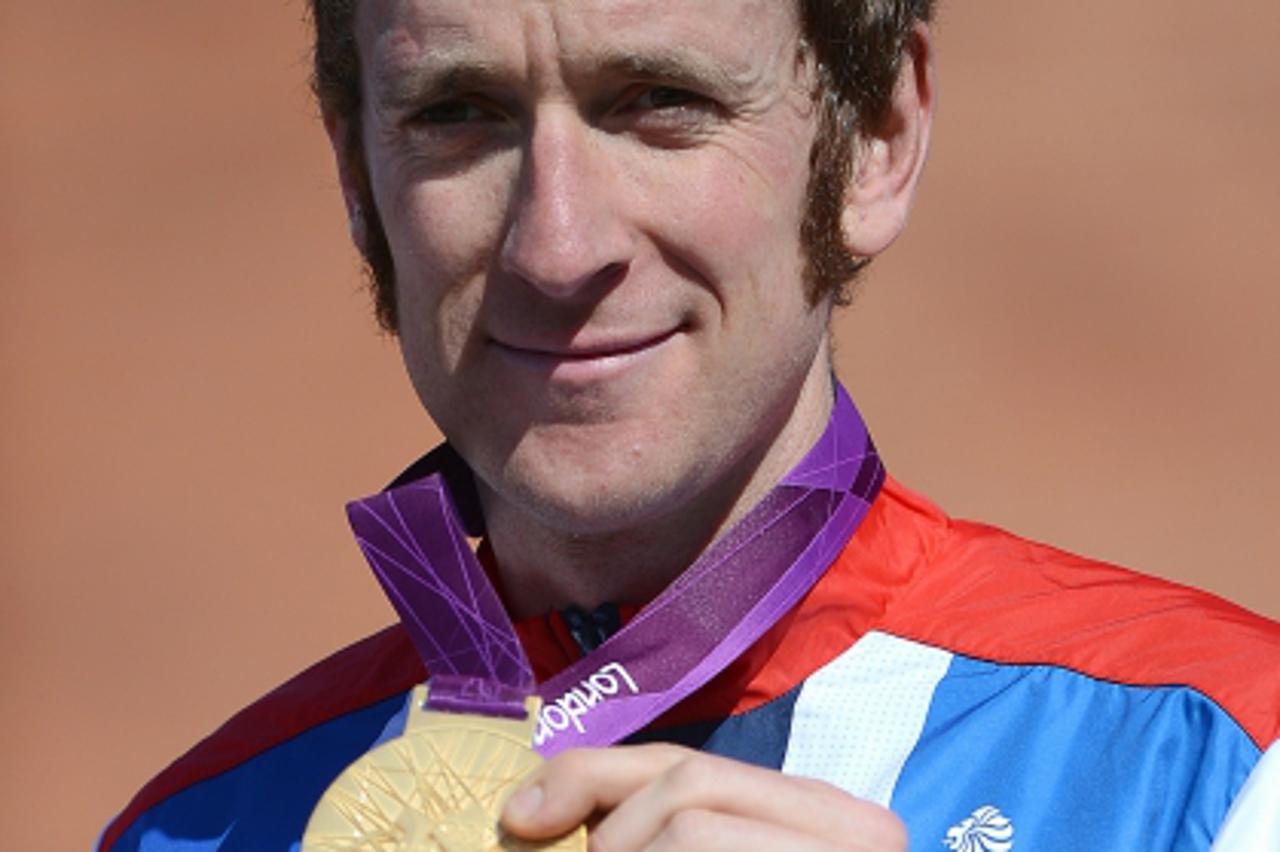 'Britain\'s Bradley Wiggins poses on the podium with his gold medal after winning the London 2012 Olympic Games men\'s individual time trial road cycling event in London on August 1, 2012. AFP PHOTO /