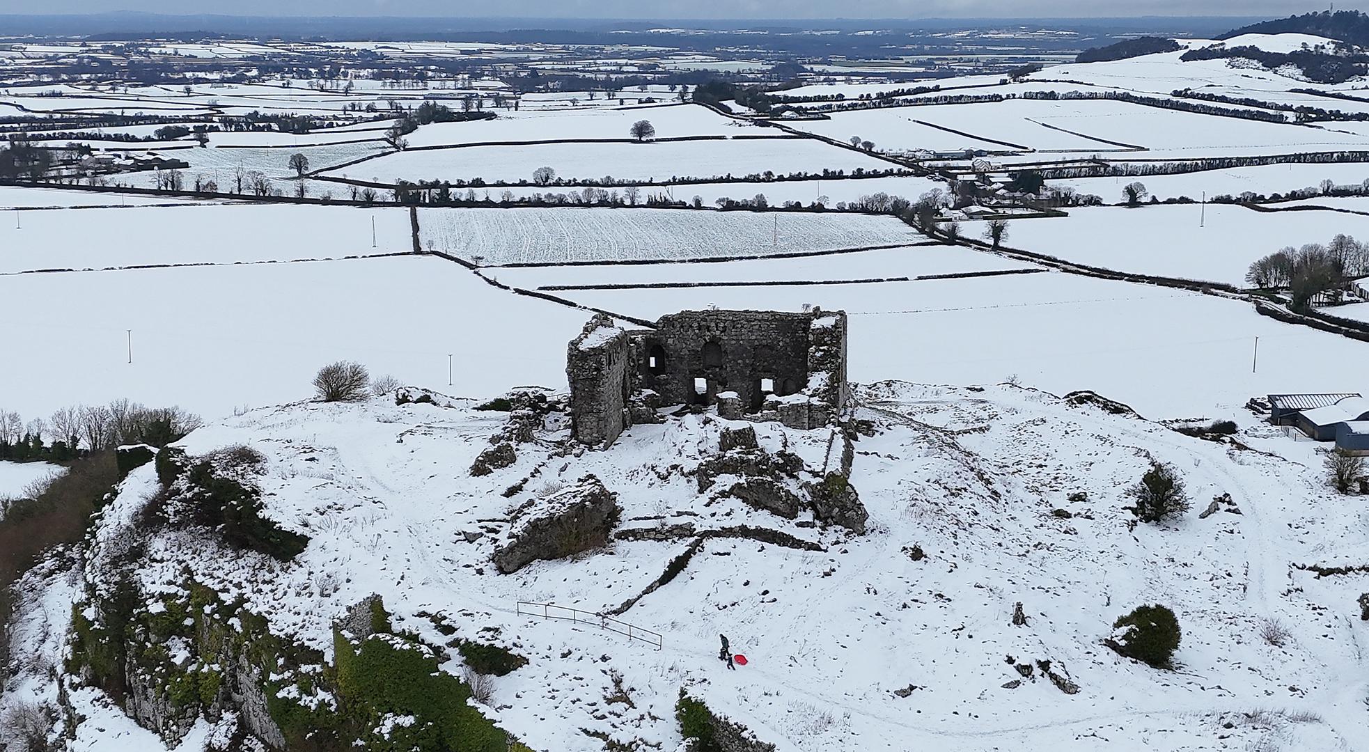 People in the snowy conditions at the Rock of Dunamase in Co. Laois. The severe winter weather has led to the closure of some schools and some public transport restrictions as well as the cancellation of several healthcare services. Picture date: Monday January 6, 2025. Photo: Niall Carson/PRESS ASSOCIATION