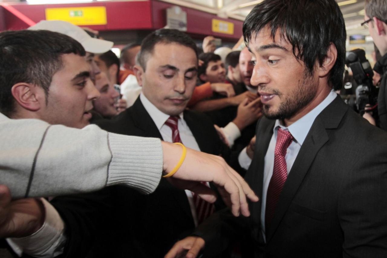 \'Fans of the Turkish national football team greet Turkish player Ibrahim Toraman as he arrives at the airport in Berlin on October 4, 2010. Turkey will face Germany in Berlin on October 8, 2010 in th