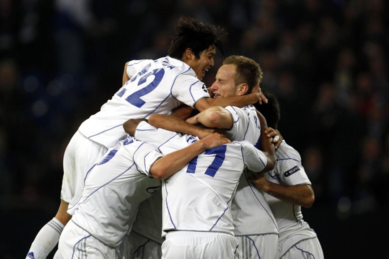 \'Schalke 04\'s Atsudo Uchida (L), Ivan Rakitic (C) and teammates celebrate a goal against Hapoel Tel Aviv during their Champions League soccer match in Gelsenkirchen October 20, 2010.    REUTERS/Ina 