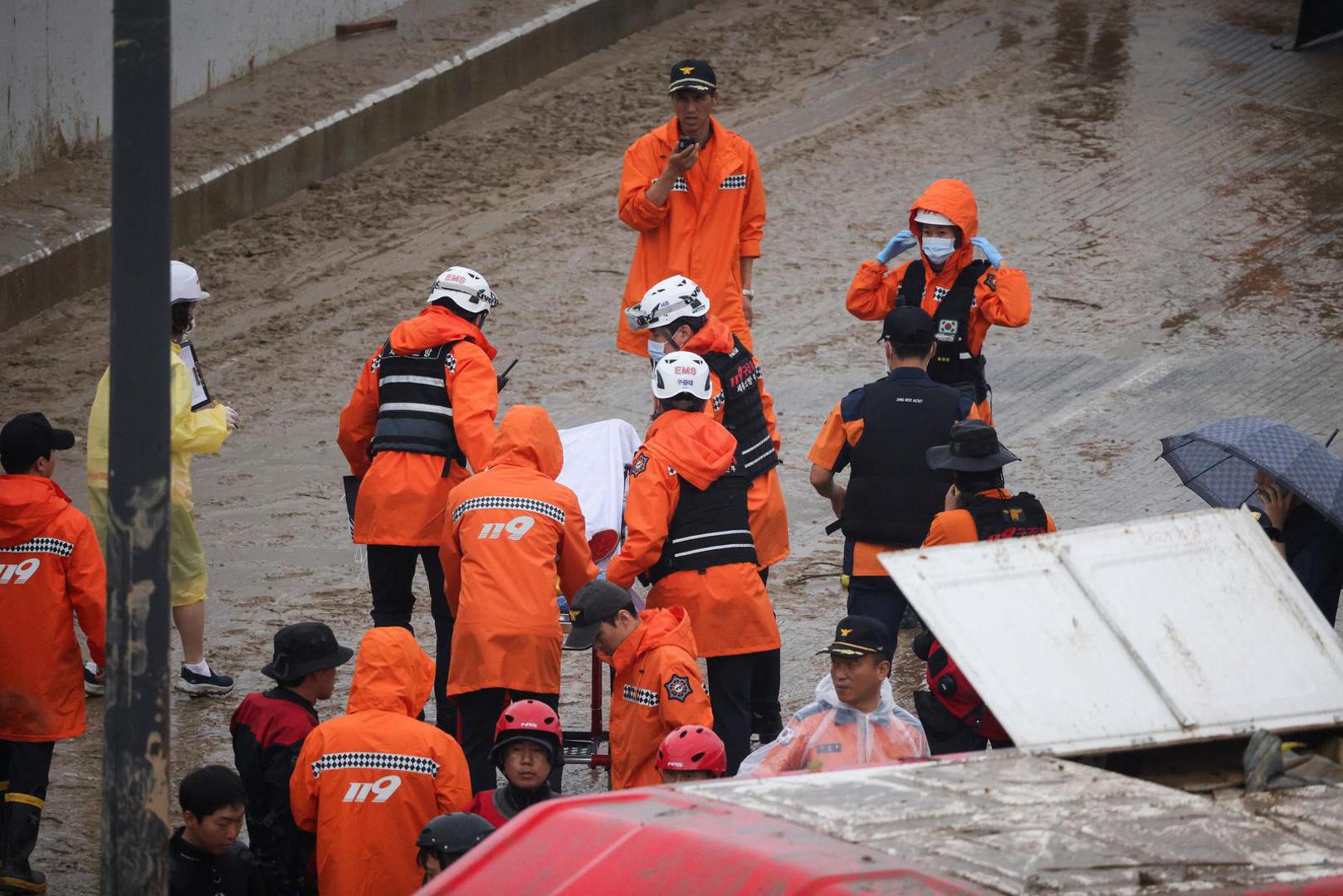 Rescue workers carry the body of a victim recovered during a search and rescue operation near an underpass that has been submerged by a flooded river caused by torrential rain in Cheongju, South Korea, July 16, 2023.   REUTERS/Kim Hong-ji Photo: KIM HONG-JI/REUTERS