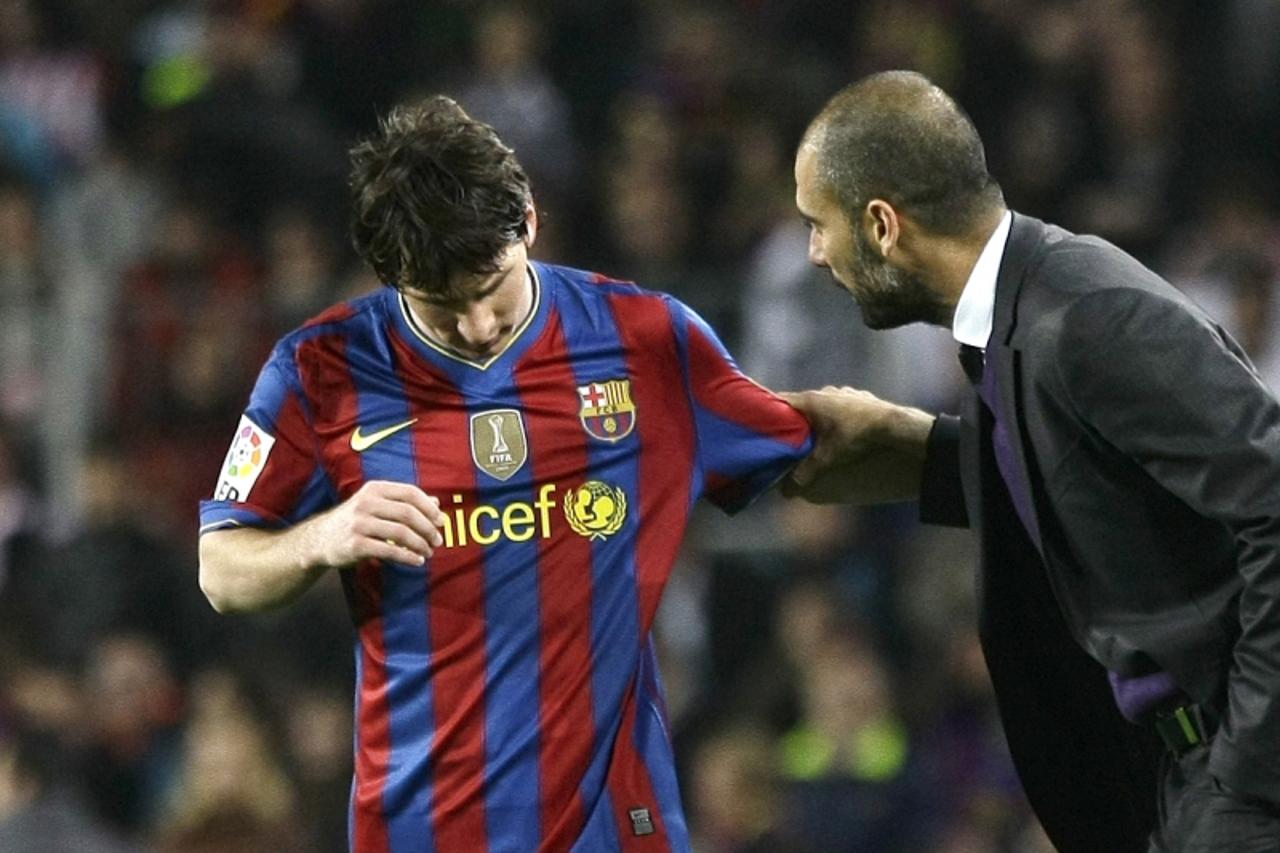 'Barcelona\'s Lionel Messi (L) talks with his coach Pep Guardiola after scoring a goal against Athletic Bilbao during their Spanish first division soccer match at Nou Camp stadium in Barcelona April 3