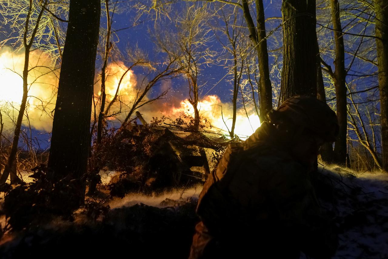 A serviceman of the National Guard of Ukraine fires a howitzer towards Russian troops at a position in a front line in Kharkiv region