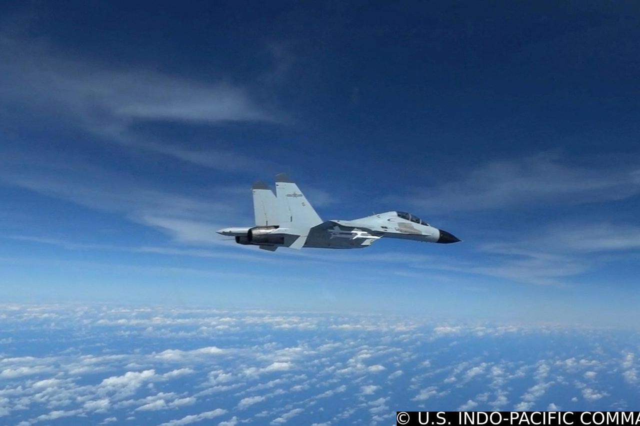 FILE PHOTO: Chinese Navy J-11 fighter jet flies close to a U.S. Air Force RC-135 aircraft over the South China Sea