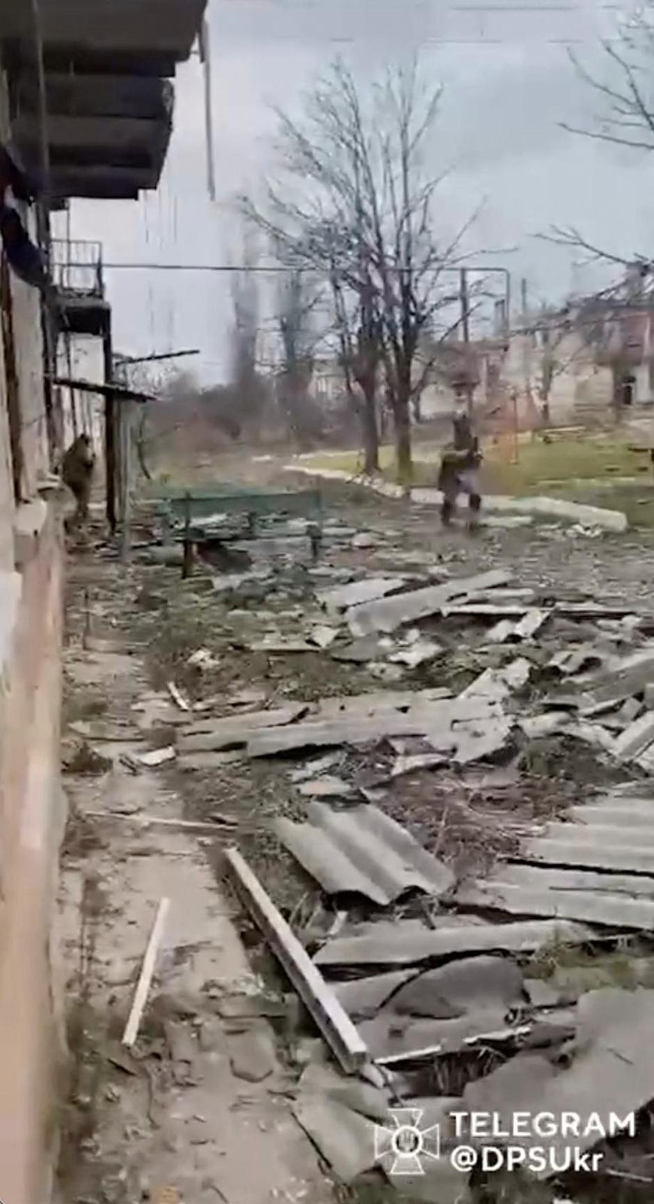 Soldier runs through debris of damaged buildings in location said to be Soledar