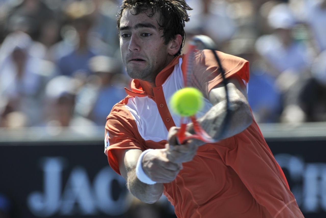 'Marin Cilic of Croatia returns against John Isner of the US during their round three men\'s singles match on the sixth day of the Australian Open tennis tournament in Melbourne on January 22, 2011.  