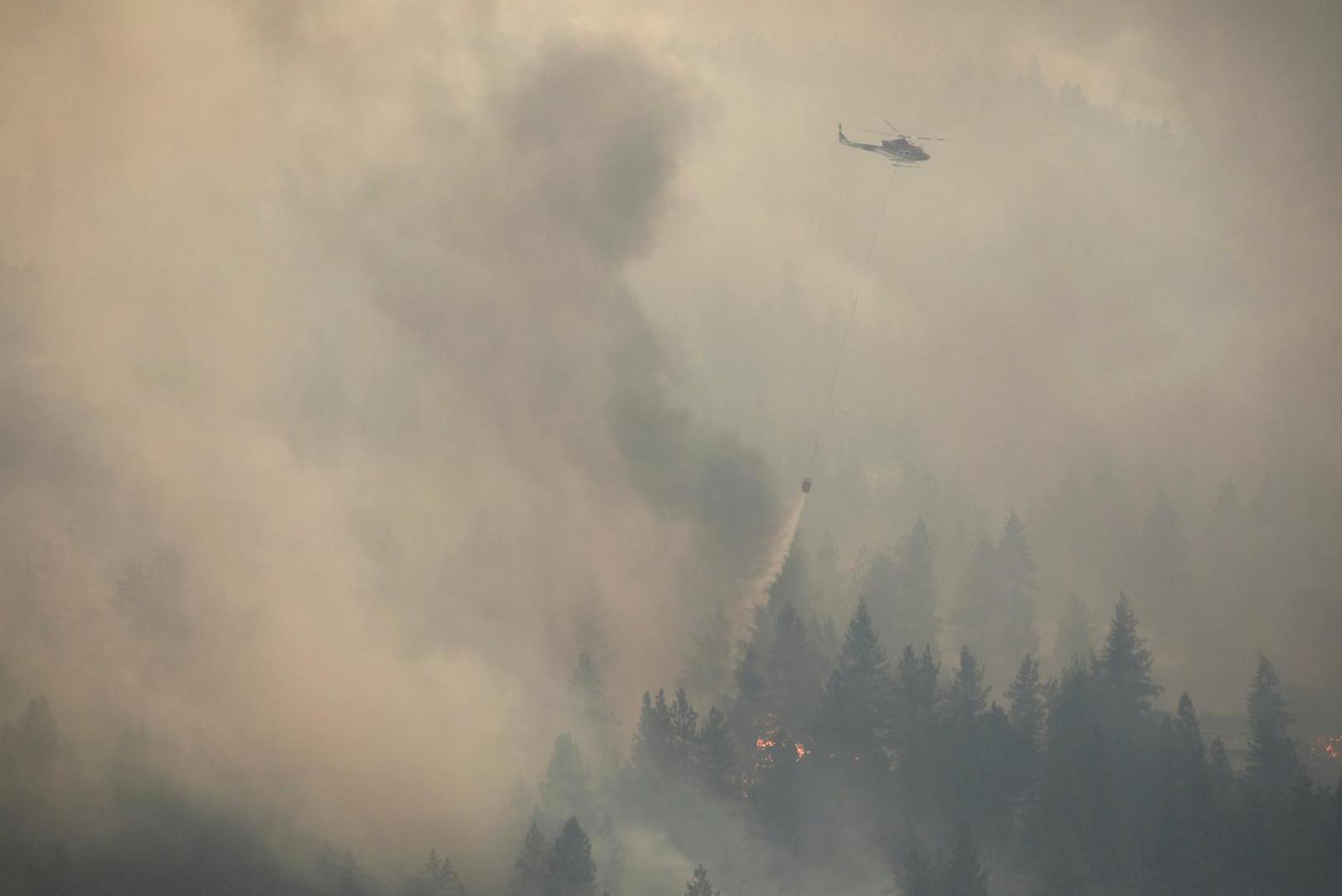 A helicopter carries a water bucket while battling the McDougall Creek wildfire outside the Okanagan community of West Kelowna, British Columbia, Canada August 18, 2023. REUTERS/Chris Helgren Photo: CHRIS HELGREN/REUTERS