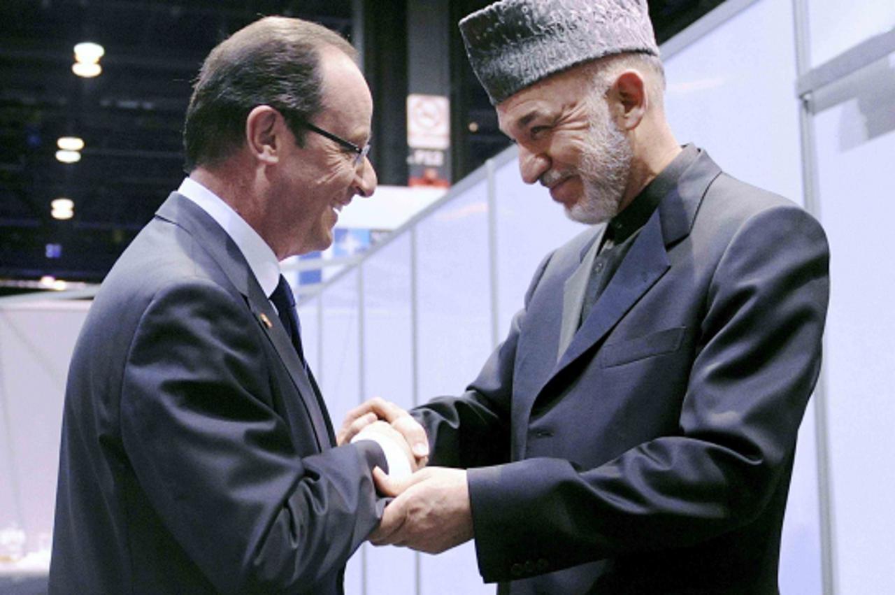 'France\'s President Francois Hollande (L) greets Afghanistan\'s President  Hamid Karzai at the NATO summit at McCormick Place in Chicago May 20, 2012.    REUTERS/Olivier Douliery/Pool  (UNITED STATES