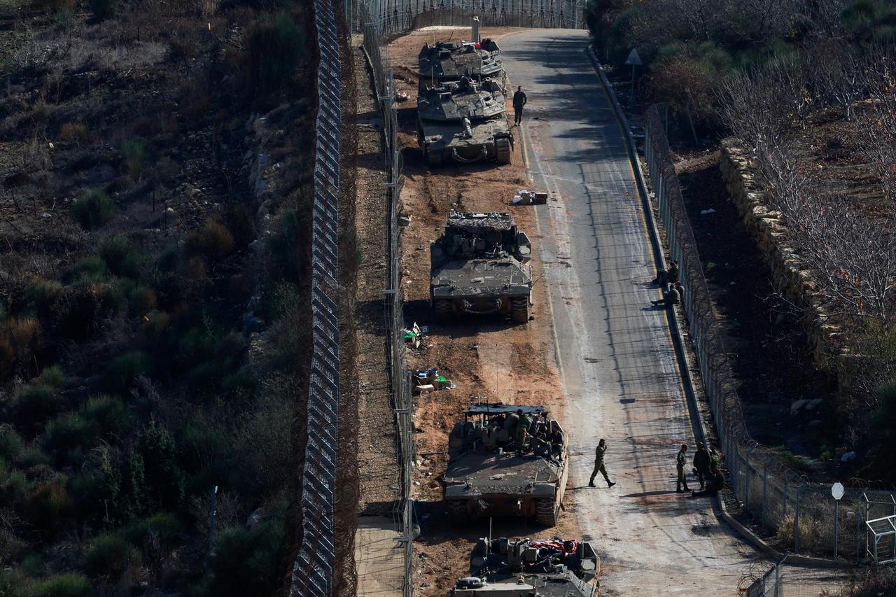 Israeli soldiers gather near the ceasefire line between Syria and the Israeli-occupied Golan Heights