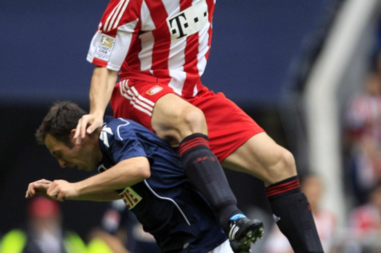 'Mark van Bommel (R) of Bayern Munich challenges Sebastian Freis of Cologne during their German Bundesliga first division soccer match in Munich September 18, 2010. REUTERS/Michael Dalder    (GERMANY 