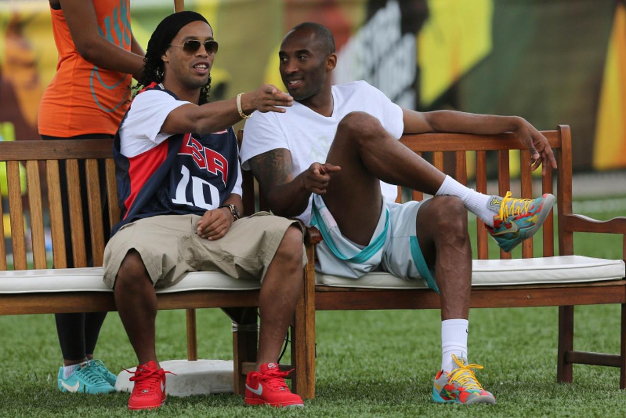 'NBA basketball player Kobe Bryant (R) of the U.S. listens to Brazilian soccer player Ronaldinho during a Nike event in Rio de Janeiro June 23, 2013. REUTERS/Satiro Sodre (BRAZIL - Tags: SPORT SOCCER 