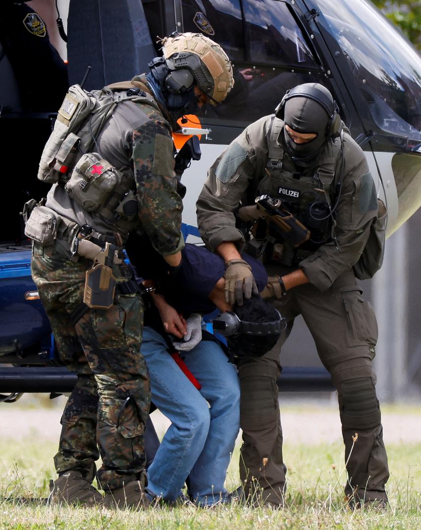 A 26-year-old Syrian man, who is the suspect in custody for a stabbing rampage in the western German city of Solingen in which several individuals were killed, is escorted by police on his way to the Federal Public Prosecutor in Karlsruhe, Germany, August 25, 2024. REUTERS/Heiko Becker Photo: Heiko Becker/REUTERS