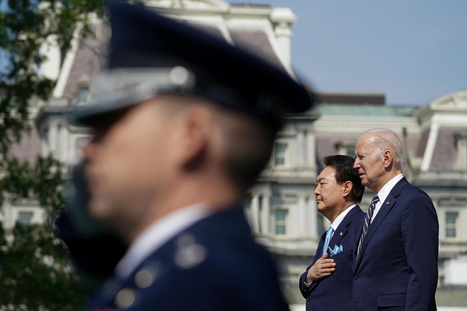 U.S. President Joe Biden and South Korea's President Yoon Suk Yeol listen to South Korea's national anthem together during an official White House State Arrival Ceremony on the South Lawn of the White House in Washington, U.S. April 26, 2023. REUTERS/Kevin Lamarque Photo: KEVIN LAMARQUE/REUTERS