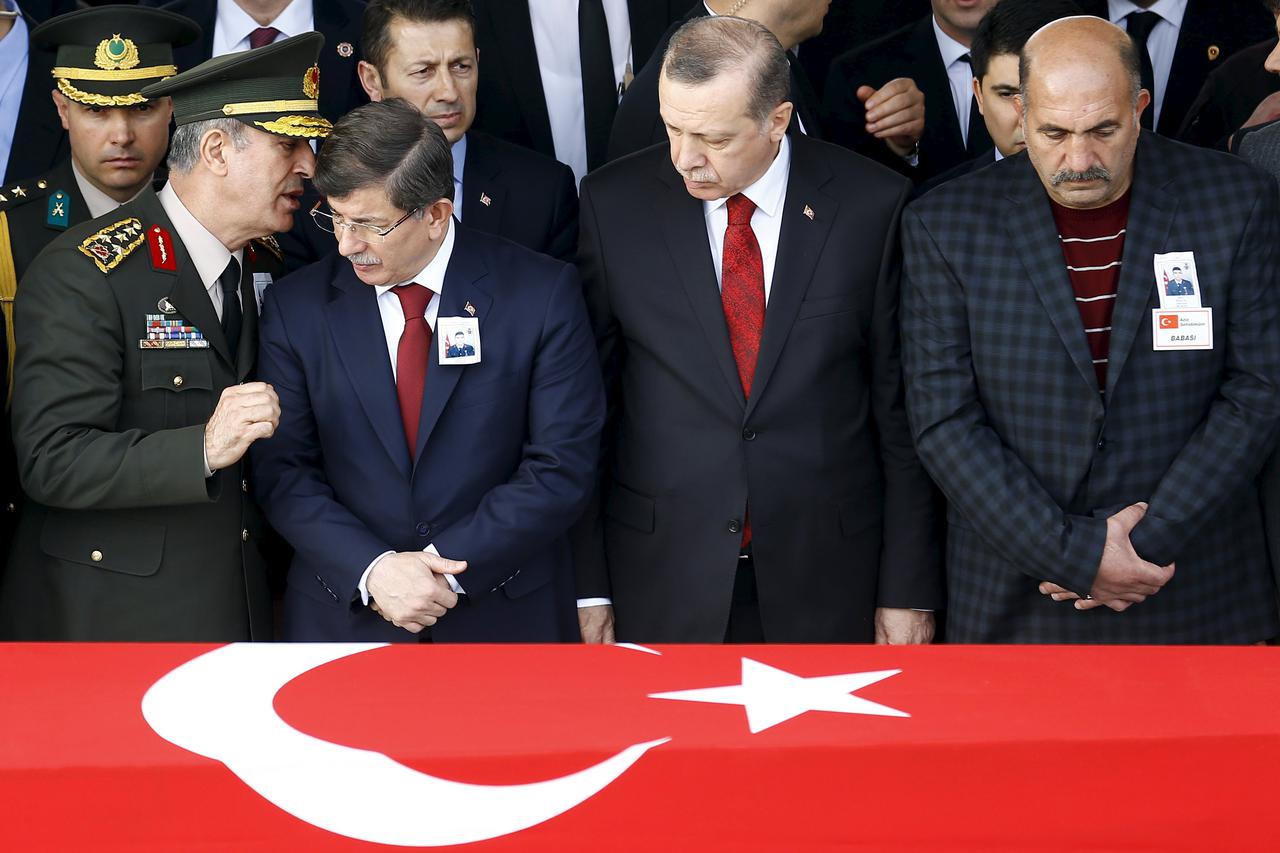 Prime Minister Ahmet Davutoglu (2nd L) chats with Chief of Staff General Hulusi Akar (L) as President Tayyip Erdogan (2nd R) looks on during a funeral ceremony for Army officer Seckin Cil in Ankara, Turkey, February 18, 2016. Army officer Cil was killed d