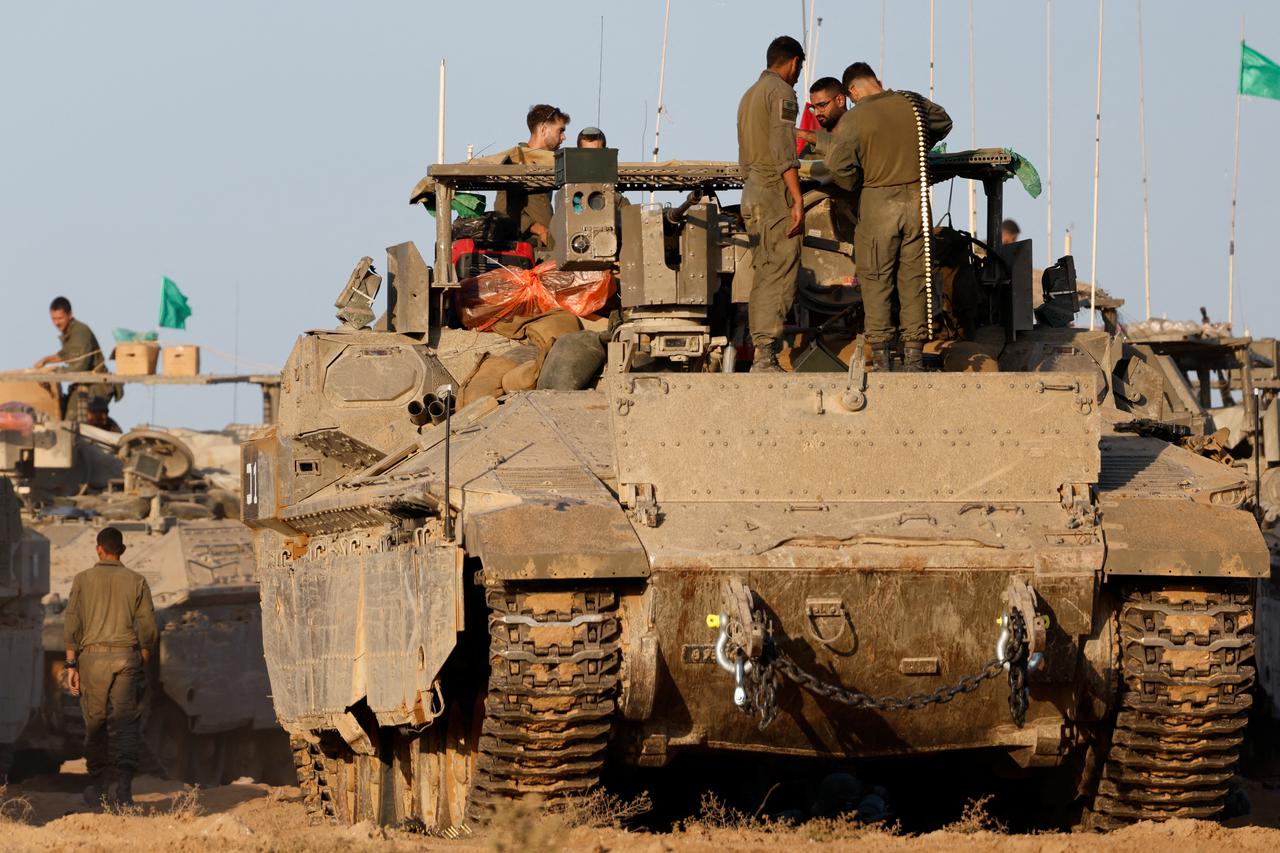 Israeli soldiers prepare their gear near the Gaza border