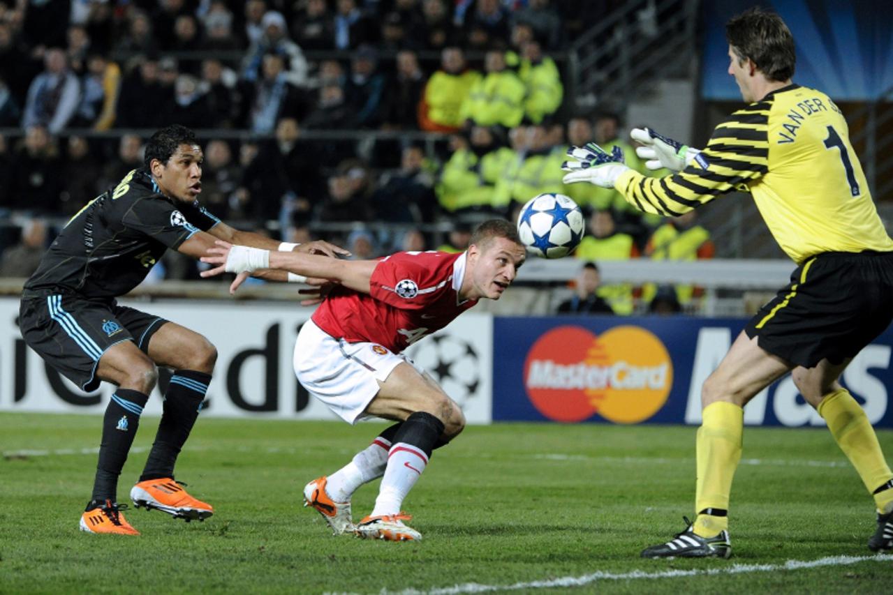 'Manchester united goalkeeper Edwin Van Der Sar of Netherlands grabs the ball in front of Olympique Marseille\'s Brazilian forward Brandao (L) and Manchester united Serbian defender Nemanja Vidic duri