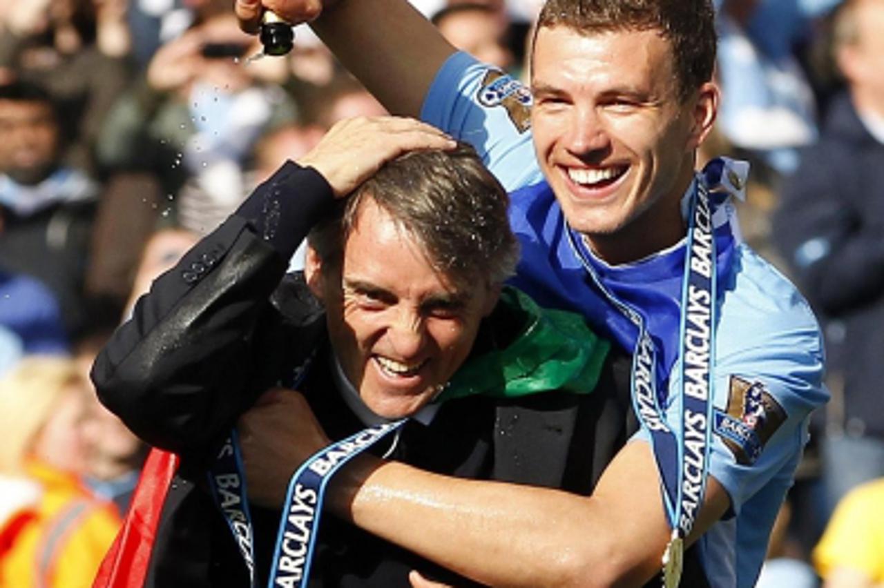 '*Alternate Crop* Manchester City manager Roberto Mancini celebrates with Edin Dzeko following the Barclays Premier League match at the Etihad Stadium, Manchester. Photo: Press Association/Pixsell'