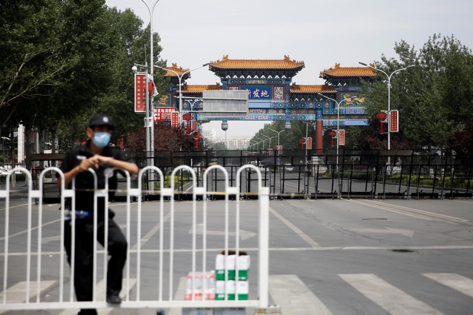 Security officer is seen at a blocked entrance to the Xinfadi wholesale market in Beijing A security officer wearing a face mask is seen at a blocked entrance to the Xinfadi wholesale market, which has been closed following cases of the coronavirus disease (COVID-19) infections, in Beijing, China June 16, 2020.  REUTERS/Tingshu Wang TINGSHU WANG