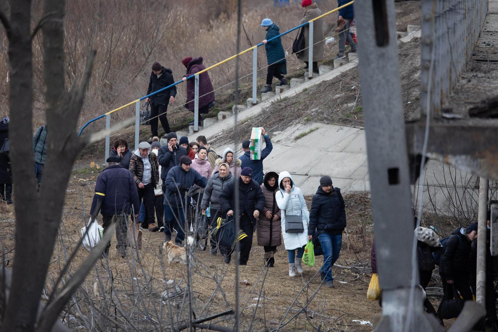 People cross a destroyed bridge as they evacuate the city of Irpin, northwest of Kyiv, during heavy shelling and bombing on March 5, 2022, 10 days after Russia launched a military invasion on Ukraine. Photo by Raphael Lafargue/ABACAPRESS.COM