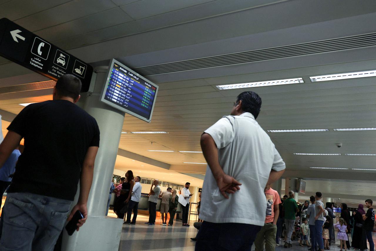 People wait for their families after their flights land at Beirut-Rafic Hariri International Airport