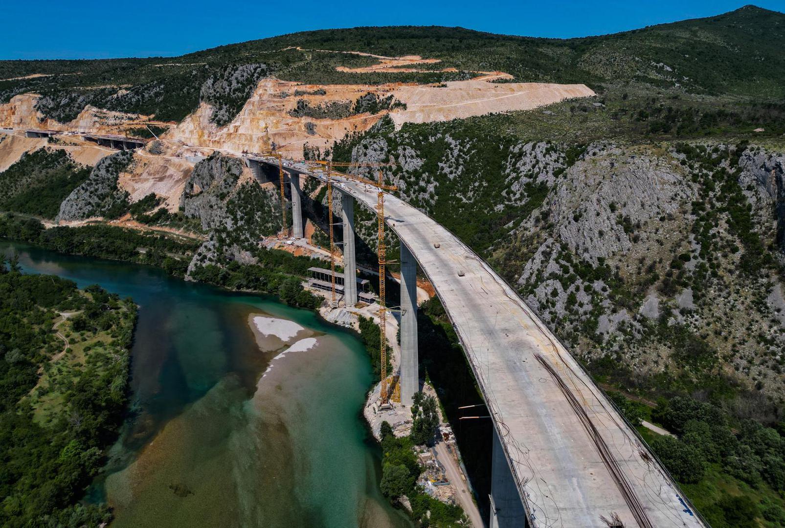 18.06.2023.,Capljina -  Jedan od najvisih mostova u regiji, most Pocitelj uskoro ce biti  spojen s lijevom obalom Neretve. Most Pocitelj visok je nesto vise od stotinu metara, dok njegova duzina iznosi 918 metara. Most ce imati dva vozna traka u svakom smjeru, te je projektiran za brzinu do 130 kilometara na sat. Specificnost ovog mosta je da se citava sirina raspona nalazi na jednostrukom nizu stupova, tj, kolnici nisu fizicki odvojeni. Most Pocitelj najveci je objekt na koridoru Vc. 


 Photo: Denis Kapetanovic/PIXSELL