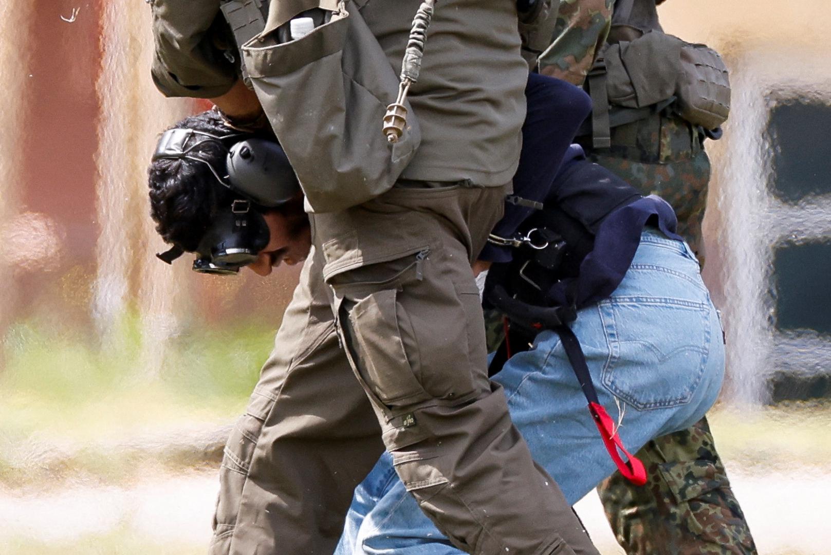 A 26-year-old Syrian man, who is the suspect in custody for a stabbing rampage in the western German city of Solingen in which several individuals were killed, is escorted by police on his way to the Federal Public Prosecutor in Karlsruhe, Germany, August 25, 2024. REUTERS/Heiko Becker Photo: Heiko Becker/REUTERS