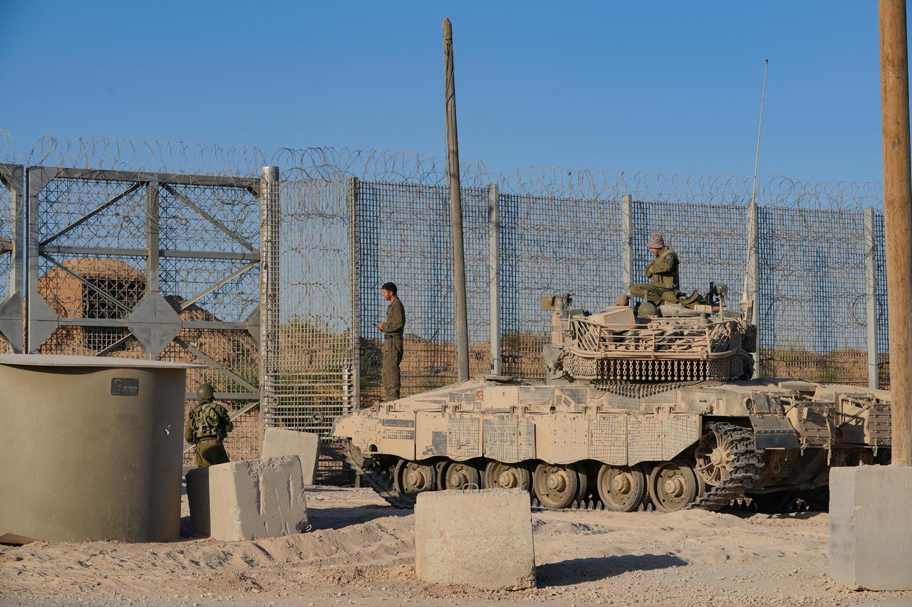 Israeli soldiers look on from atop a military vehicle near the Israel-Gaza border