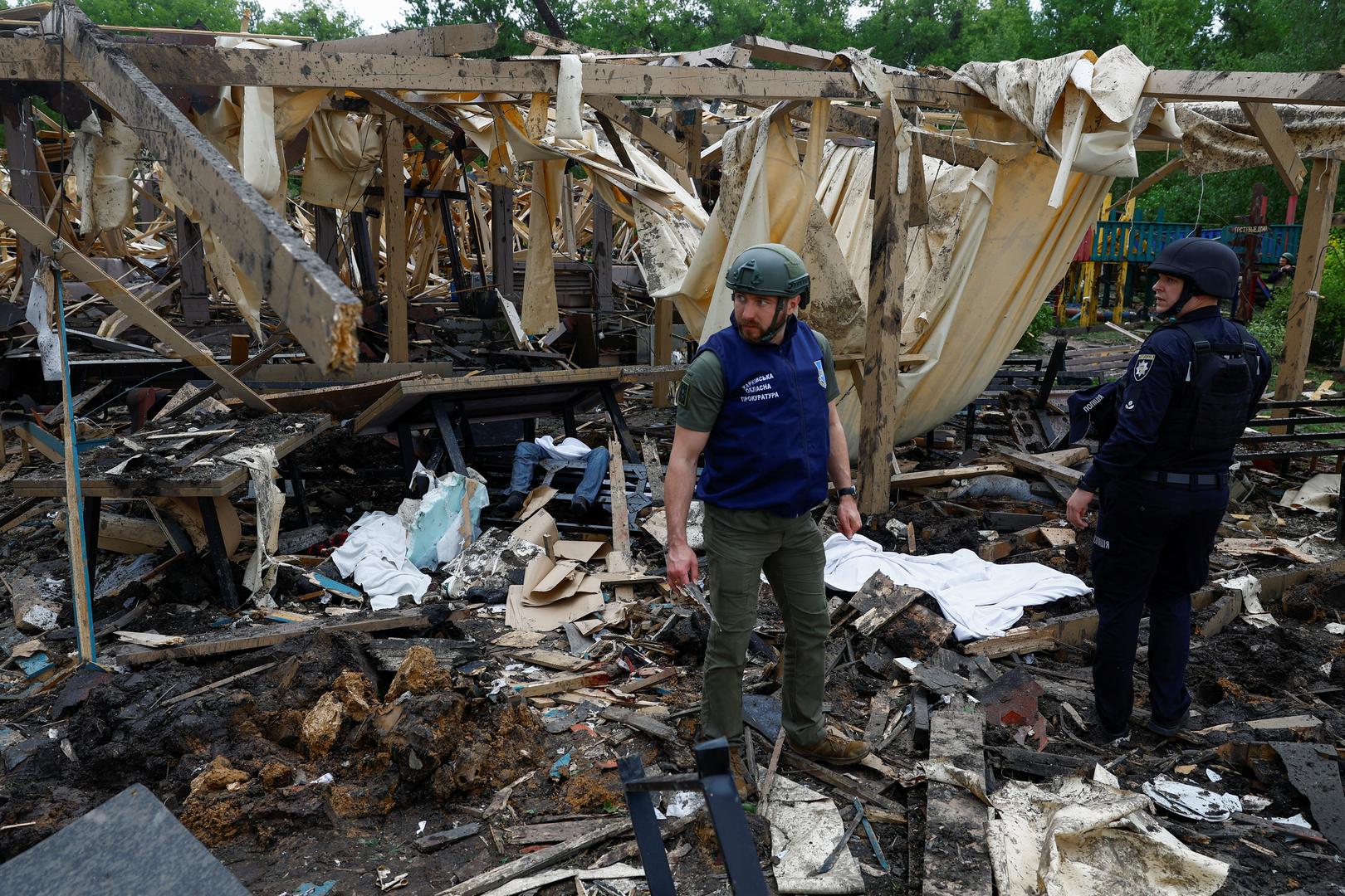 SENSITIVE MATERIAL. THIS IMAGE MAY OFFEND OR DISTURB A war crimes prosecutor and a police officer stand next to the bodies of people killed by a Russian missile strike on a resort compound in Kharkiv, amid Russia's attack on Ukraine May 19, 2024. REUTERS/Valentyn Ogirenko Photo: VALENTYN OGIRENKO/REUTERS