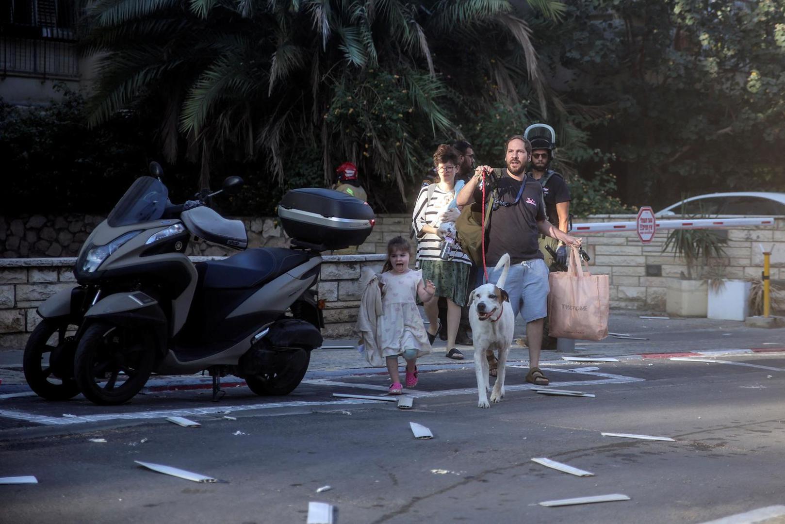 Israelis react on a street as rocket attacks are launched from the Gaza Strip, in Tel Aviv, Israel October 7, 2023. REUTERS/Itai Ron Photo: ITAI RON/REUTERS