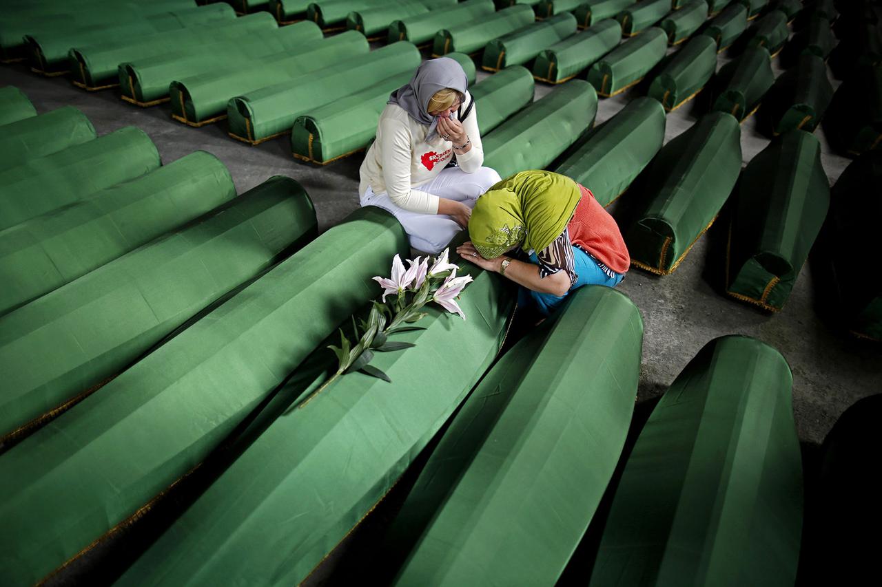 Bosnian Muslim women cry near the coffin of their relative, which is one of the 175 coffins of newly identified victims from the 1995 Srebrenica massacre, in Potocari Memorial Center, near Srebrenica, July 10, 2014. Family members, foreign dignitaries and