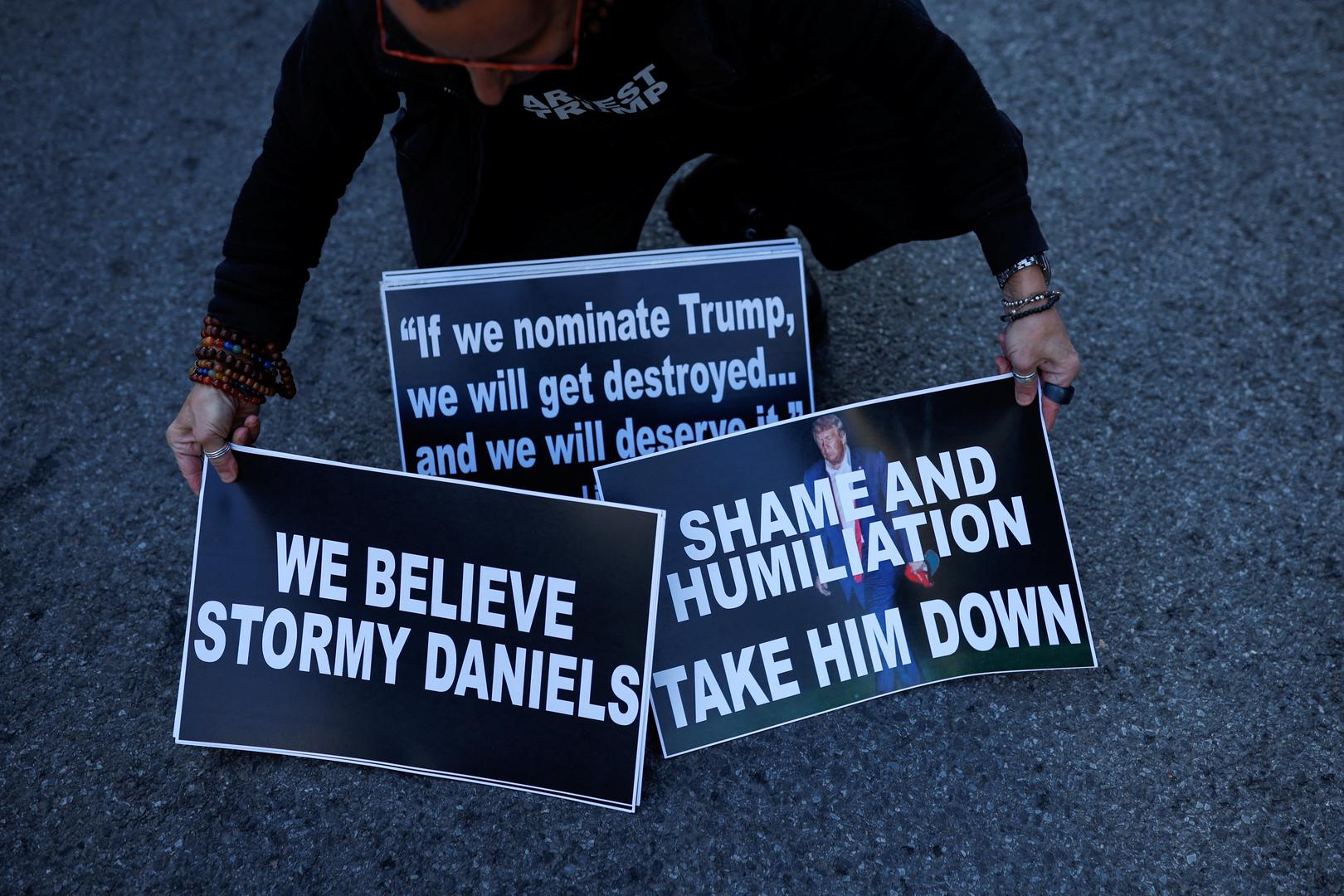 An anti-Trump protester holds signs outside Manhattan Criminal Courthouse, after former U.S. President Donald Trump's indictment by a Manhattan grand jury following a probe into hush money paid to porn star Stormy Daniels, in New York City, U.S., April 4, 2023. REUTERS/Amanda Perobelli Photo: AMANDA PEROBELLI/REUTERS