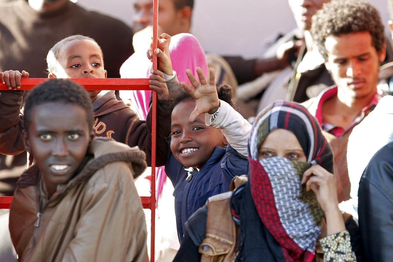 A child waves before disembarking from tug boat Asso29 in the Sicilian harbour of Pozzallo, southern Italy, May 4, 2015. Nearly 5,800 migrants were plucked from boats off the coast of Libya and 10 bodies were recovered in less than 48 hours, Italy's coast