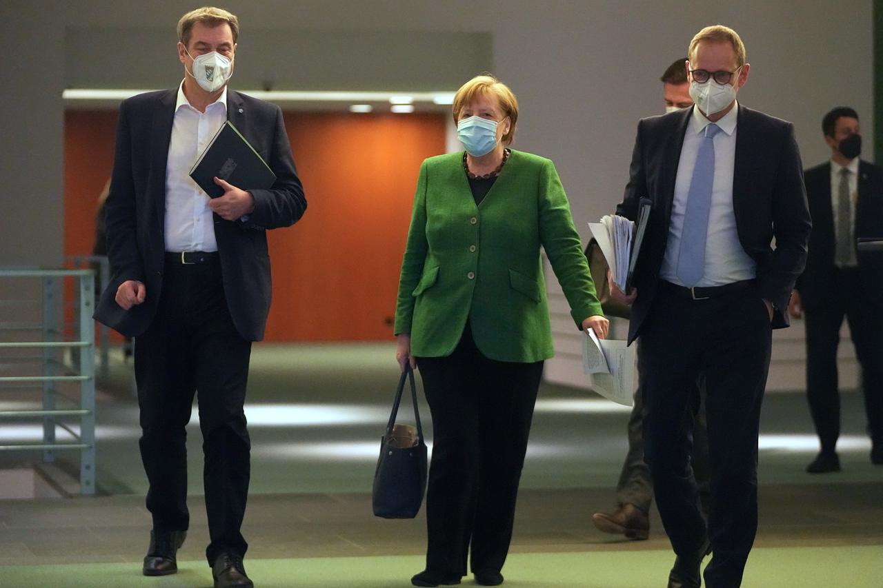 Germany's Merkel walks with Bavarian State Premier Soeder and Berlin Mayor Mueller after discussing COVID-19 lockdown extension with state premiers