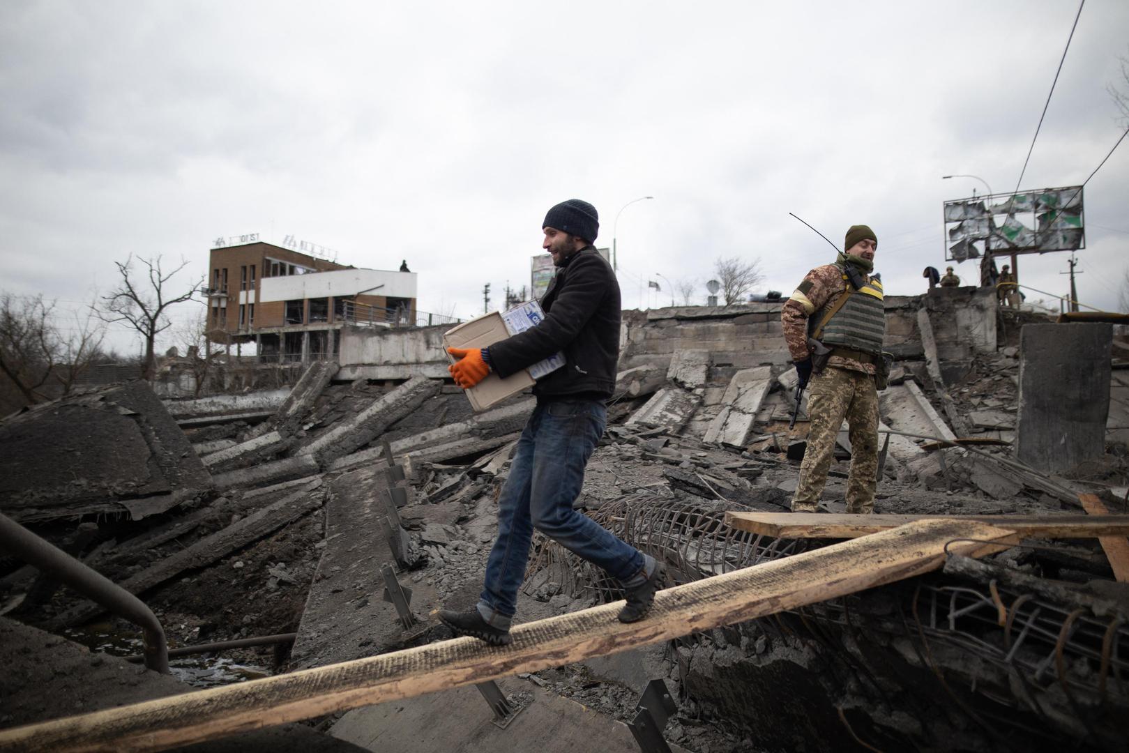 People cross a destroyed bridge as they evacuate the city of Irpin, northwest of Kyiv, during heavy shelling and bombing on March 5, 2022, 10 days after Russia launched a military invasion on Ukraine. Photo by Raphael Lafargue/ABACAPRESS.COM