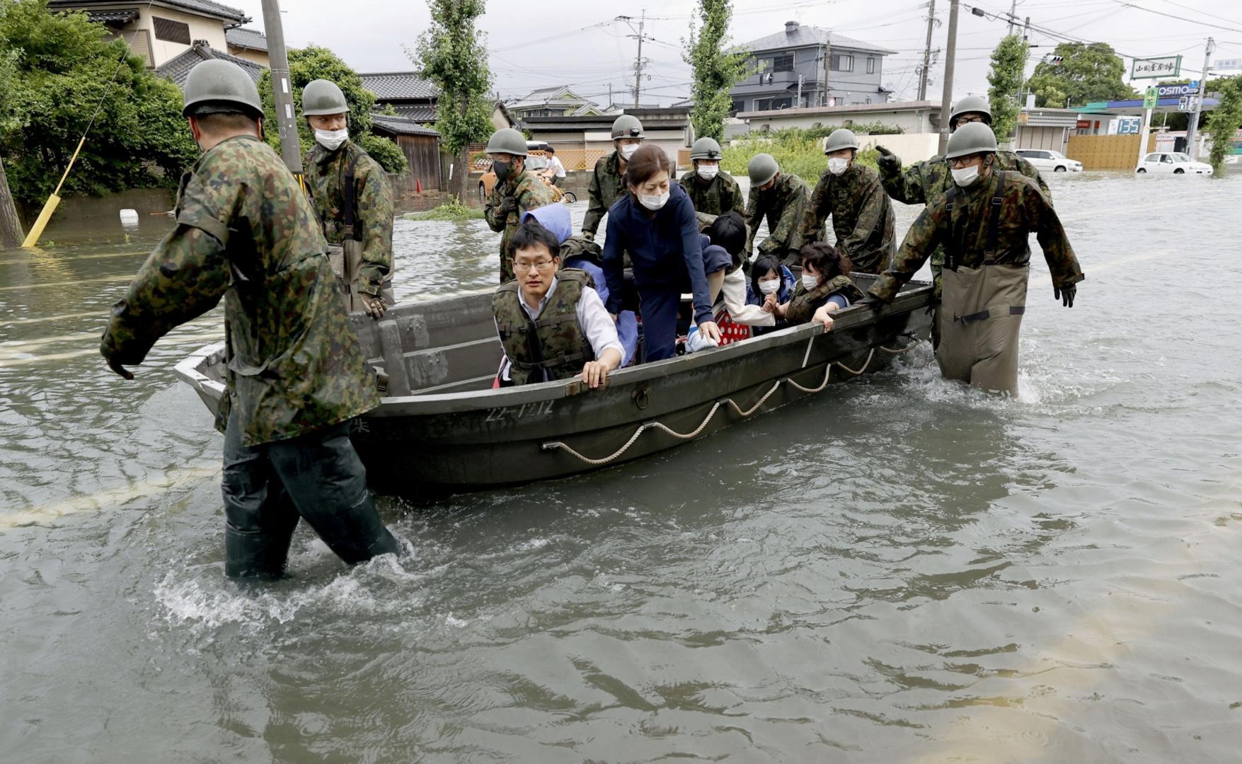 Japanese Self-Defense Force personnel push a boat carrying evacuees in the Fukuoka Prefecture city of Omuta on July 7, 2020, as torrential rain continues to hit Japan's southwestern region of Kyushu. (Kyodo)
==Kyodo
 Photo via Newscom Newscom/PIXSELL