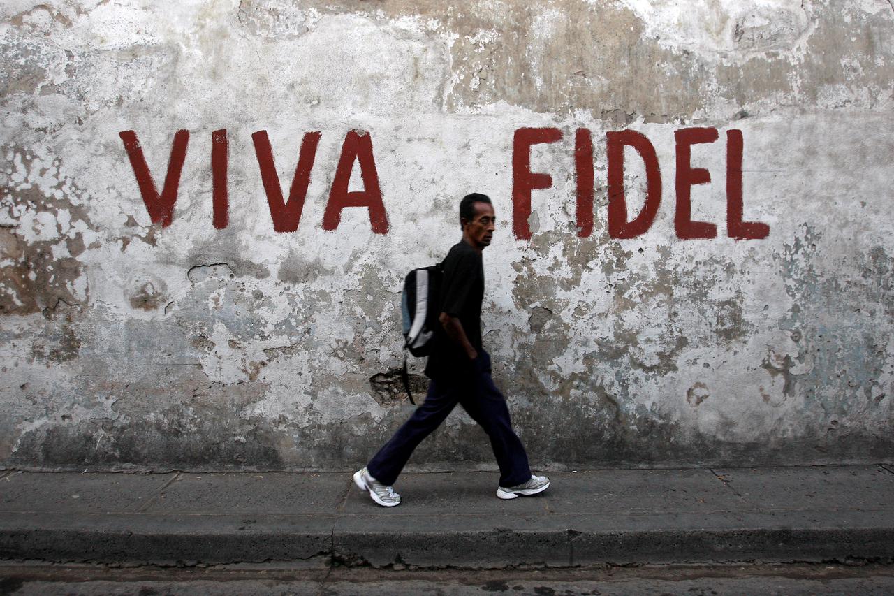 A man walks past a graffitti that reads 