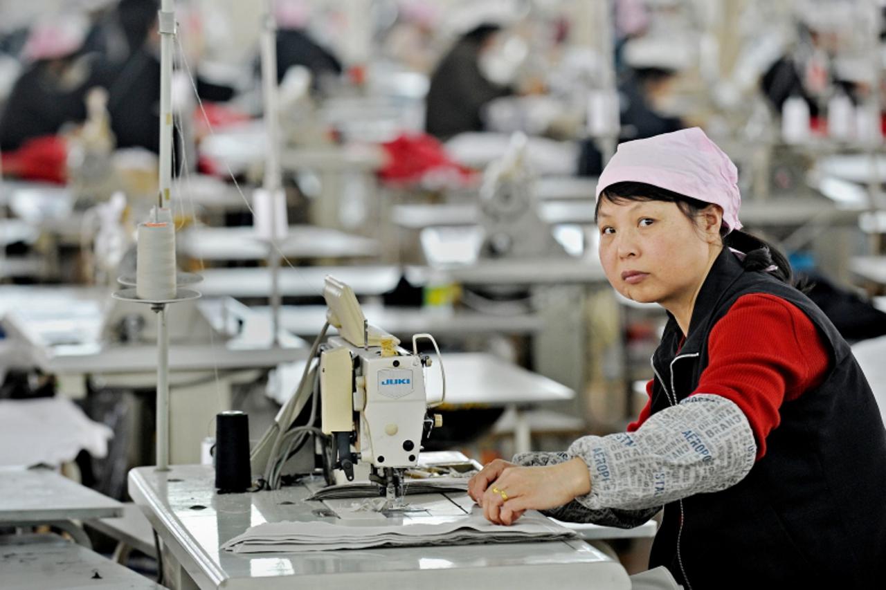 'A Chinese worker looks on from her work station after lunch at a garment factory in Pinghu some 100 kms from Shanghai on April 10, 2010.  China posted its first monthly trade deficit in six years in 